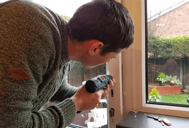 Professional locksmith fixing a UPVC door